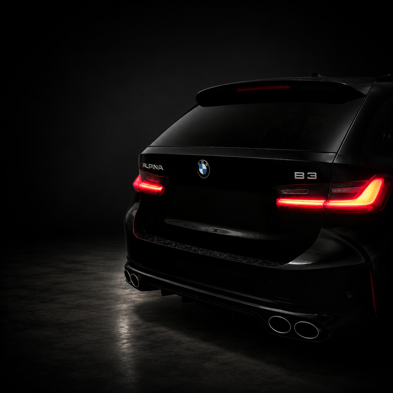 Heckansicht eines schwarzen Alpina B3 mit leuchtenden Rückleuchten